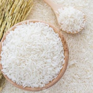 White rice in bowl and a bag, a wooden spoon and rice plant on white rice background, Top view with copy space